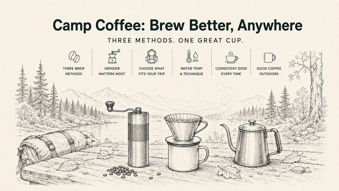 Hand-crank coffee grinder and pour-over dripper on a camp table beside a steaming kettle at a forest campsite