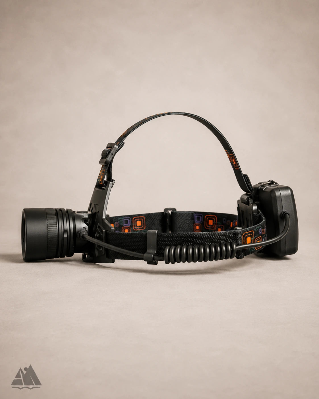Side profile of LED headlamp showing lens, coiled cable, and battery pack