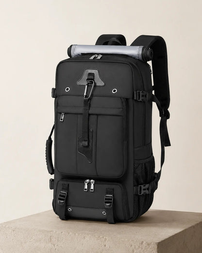 Black travel backpack photographed in a minimal studio editorial setting