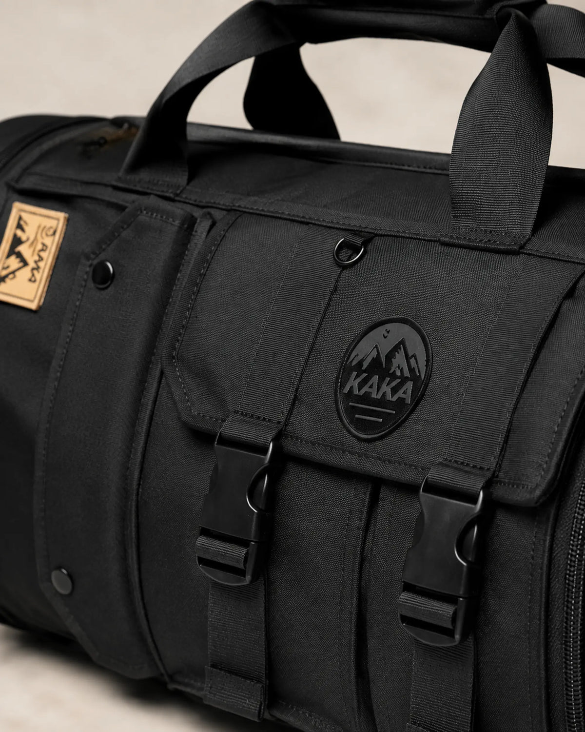 Close-up of KAKA emblem, buckles and Oxford fabric on the black bag