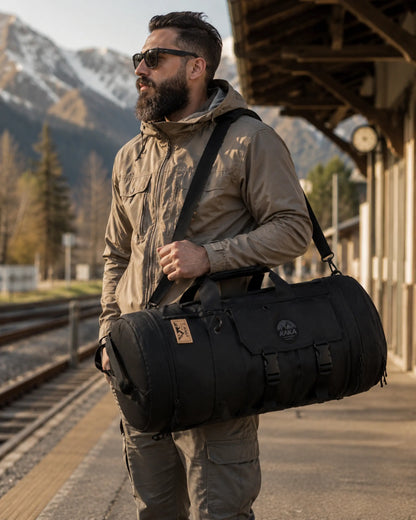 Black multi-carry travel bag carried at a mountain rail platform