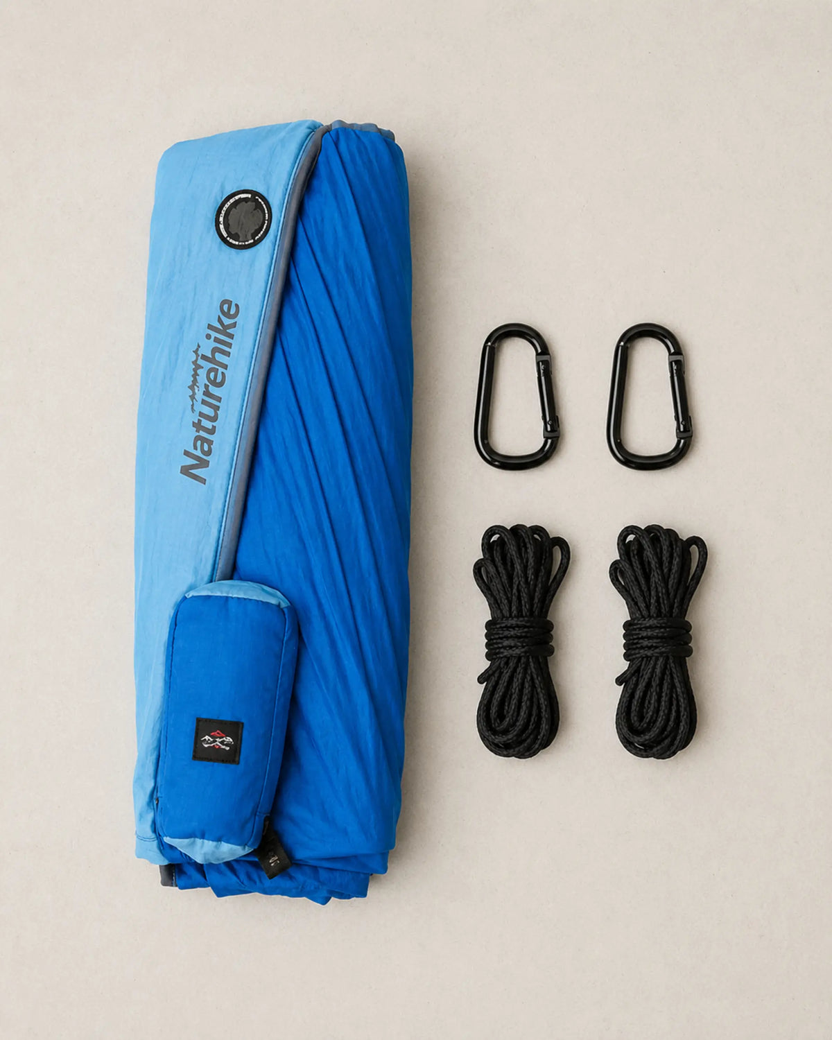 Blue double hammock kit with two carabiners and two suspension ropes arranged flat