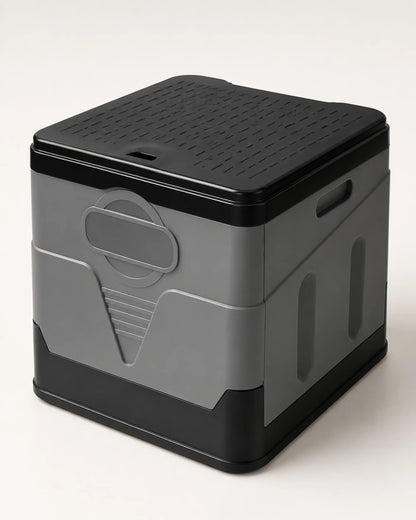 Grey foldable portable camping toilet fully assembled with the ribbed black lid closed in a front view