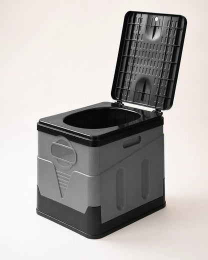 Grey foldable portable camping toilet shown from the right with raised lid, molded panels and carry handle