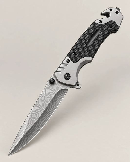 KK6 folding survival knife with patterned stainless steel blade on a warm stone-grey background