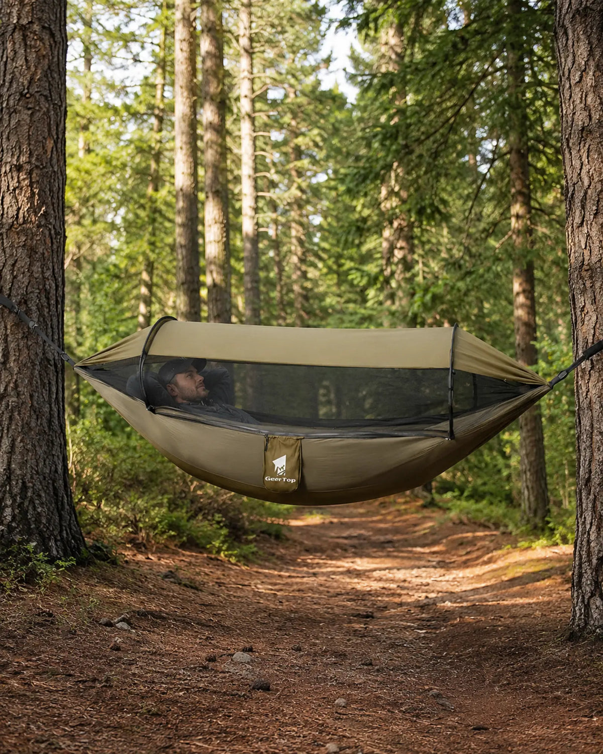 Hiker resting inside the GeerTop mosquito-net hammock on a forest trail