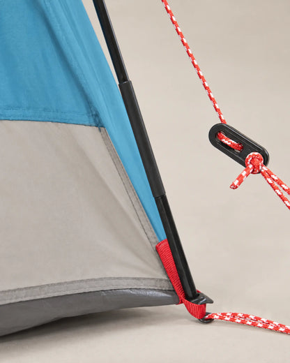 Close-up of blue tent fabric, black pole and red guyline tensioner