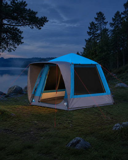 Blue large family camping tent beside a calm lake at dawn