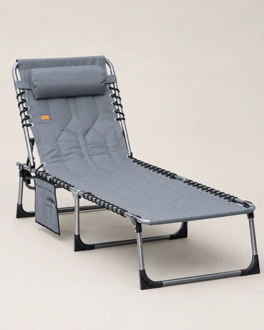 Grey padded folding chaise lounge with adjustable backrest, pillow and side pocket in a front three-quarter view