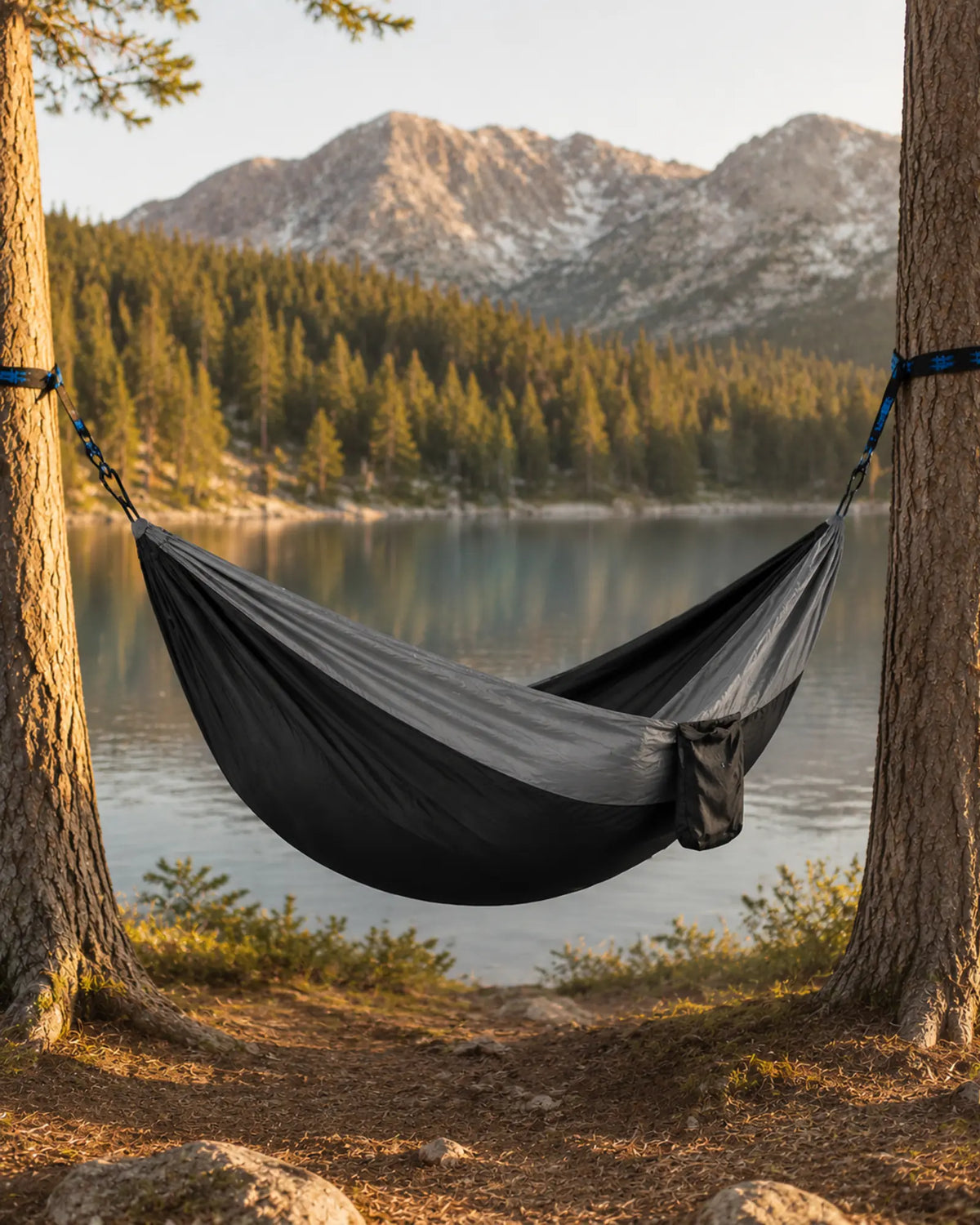 Empty Black fight gray camping hammock beside a mountain lake