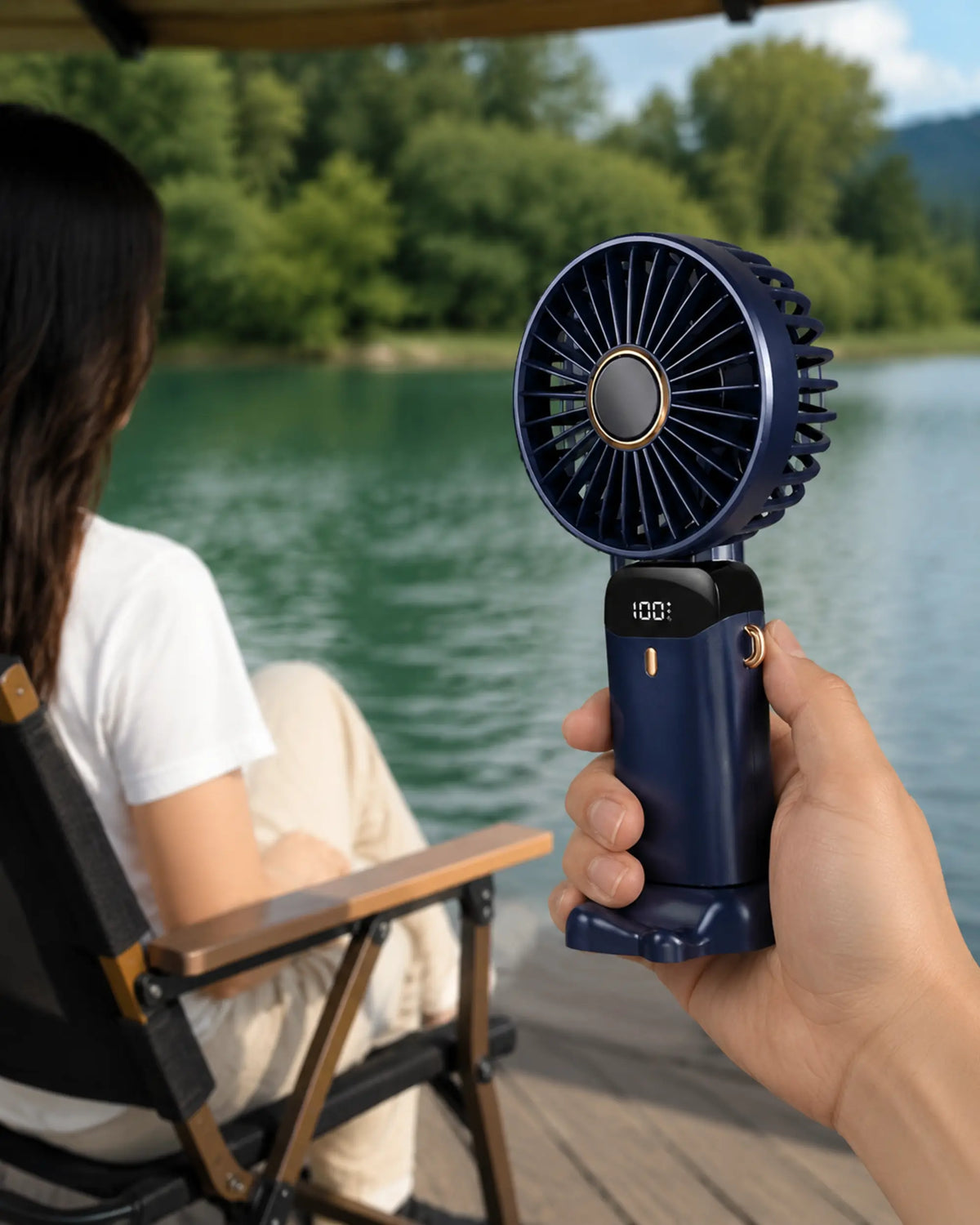 Navy Blue handheld fan used at a shaded lakeside rest area