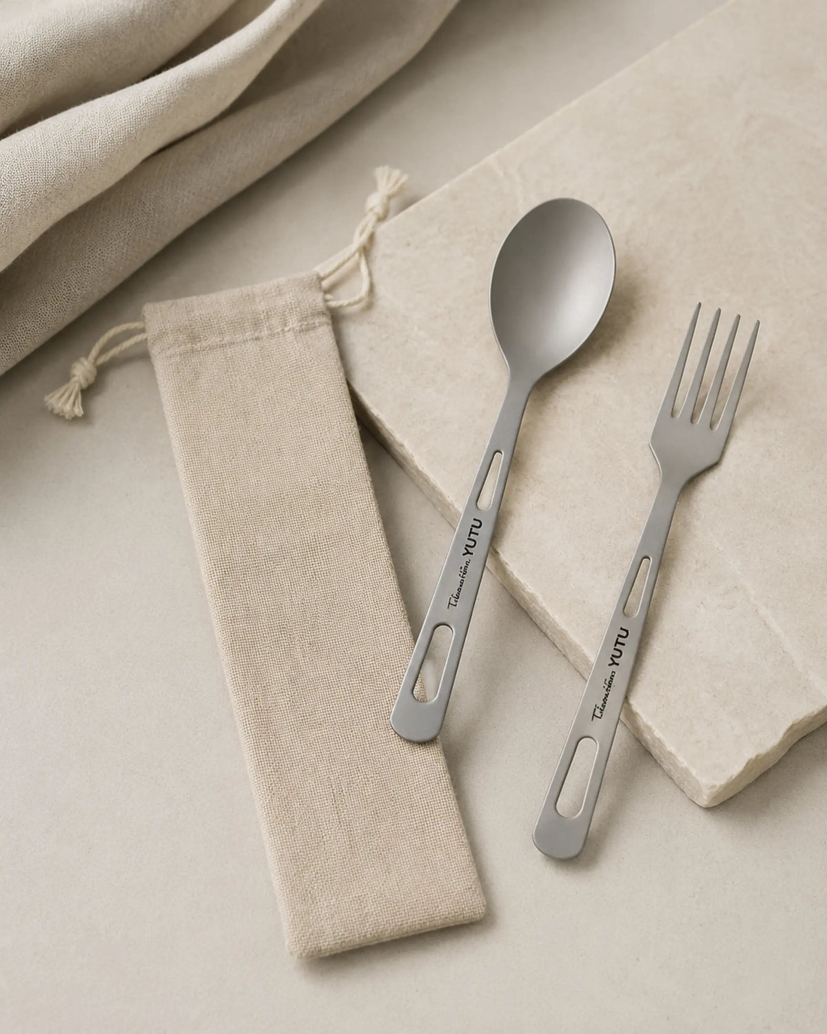 Editorial ARWE titanium spoon fork and linen pouch on pale stone