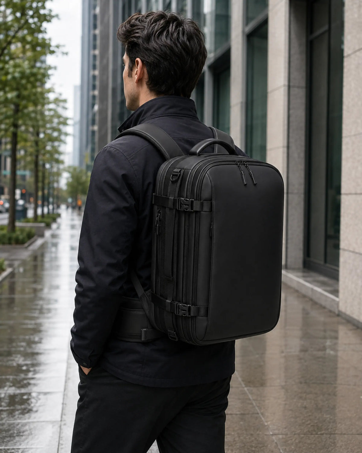 Black business travel backpack worn by a commuter on a modern city street