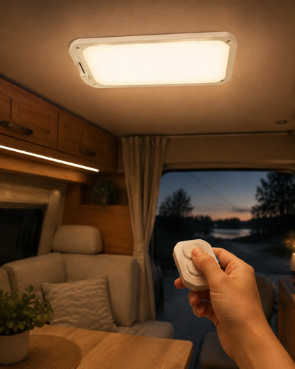 Hand using the remote for a warm dimmable ceiling light inside a camper van