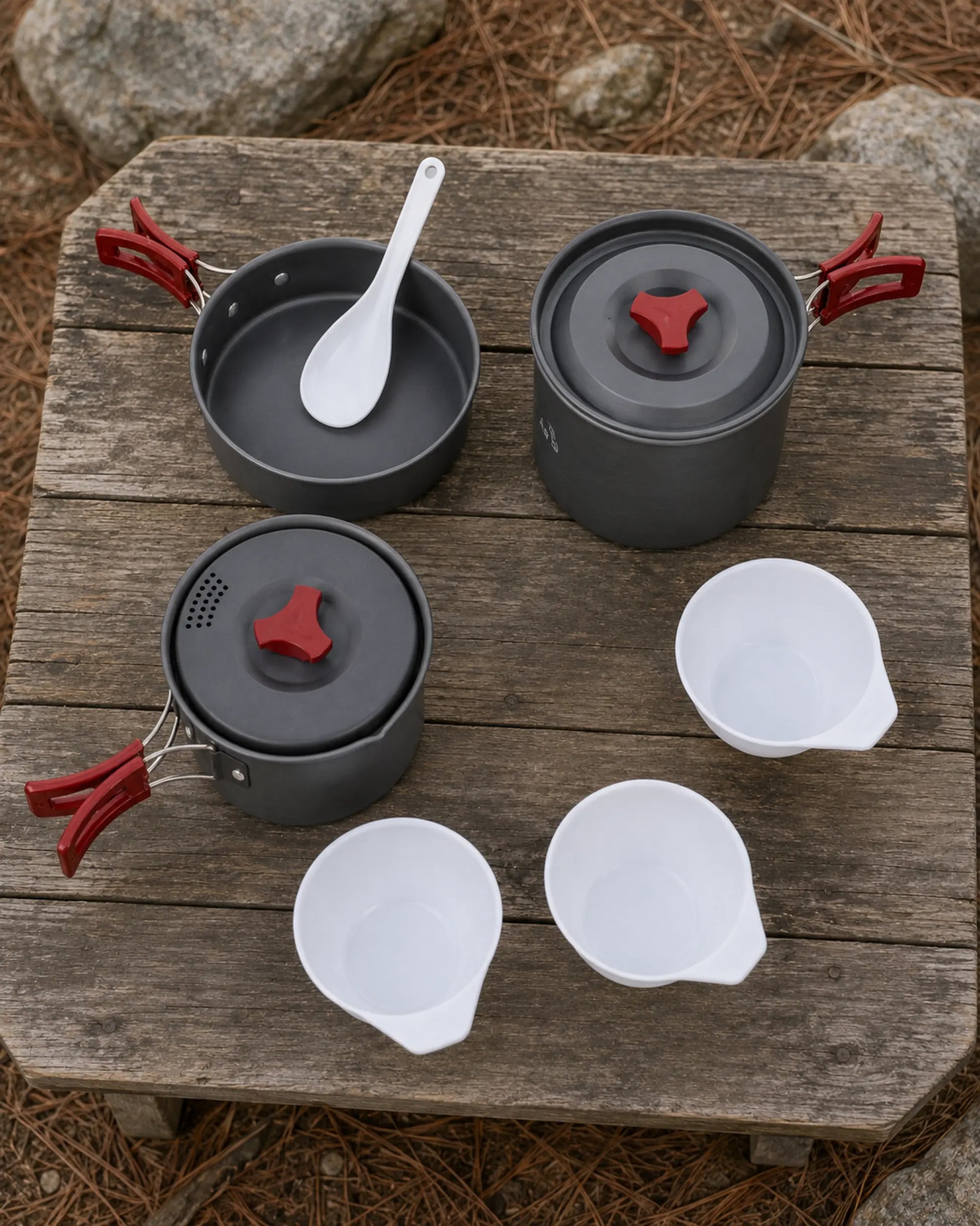 Fire-Maple package 202 cookware arranged outdoors on a rustic camp table