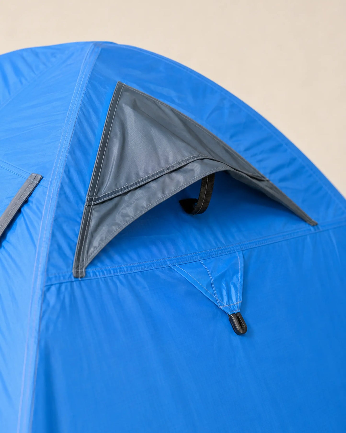 Close-up of FLYTOP blue tent ventilation flap, zipper and reinforced stitching