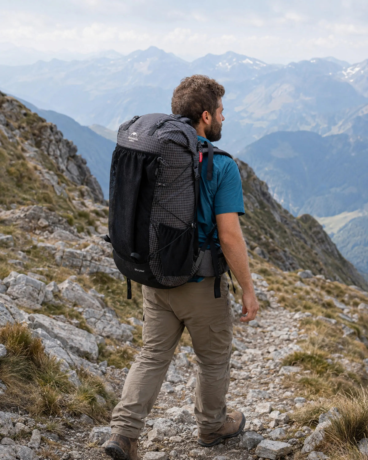 Hiker carrying Naturehike 60L Upgraded Black backpack on a mountain trail