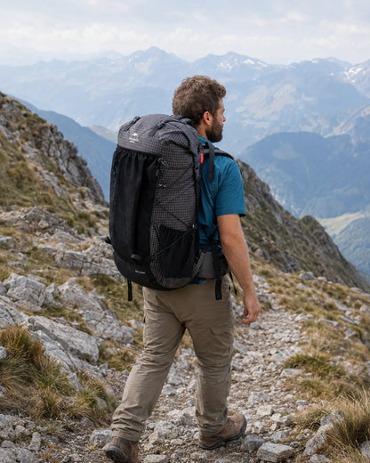 Hiker carrying Naturehike 60L Upgraded Black backpack on a mountain trail