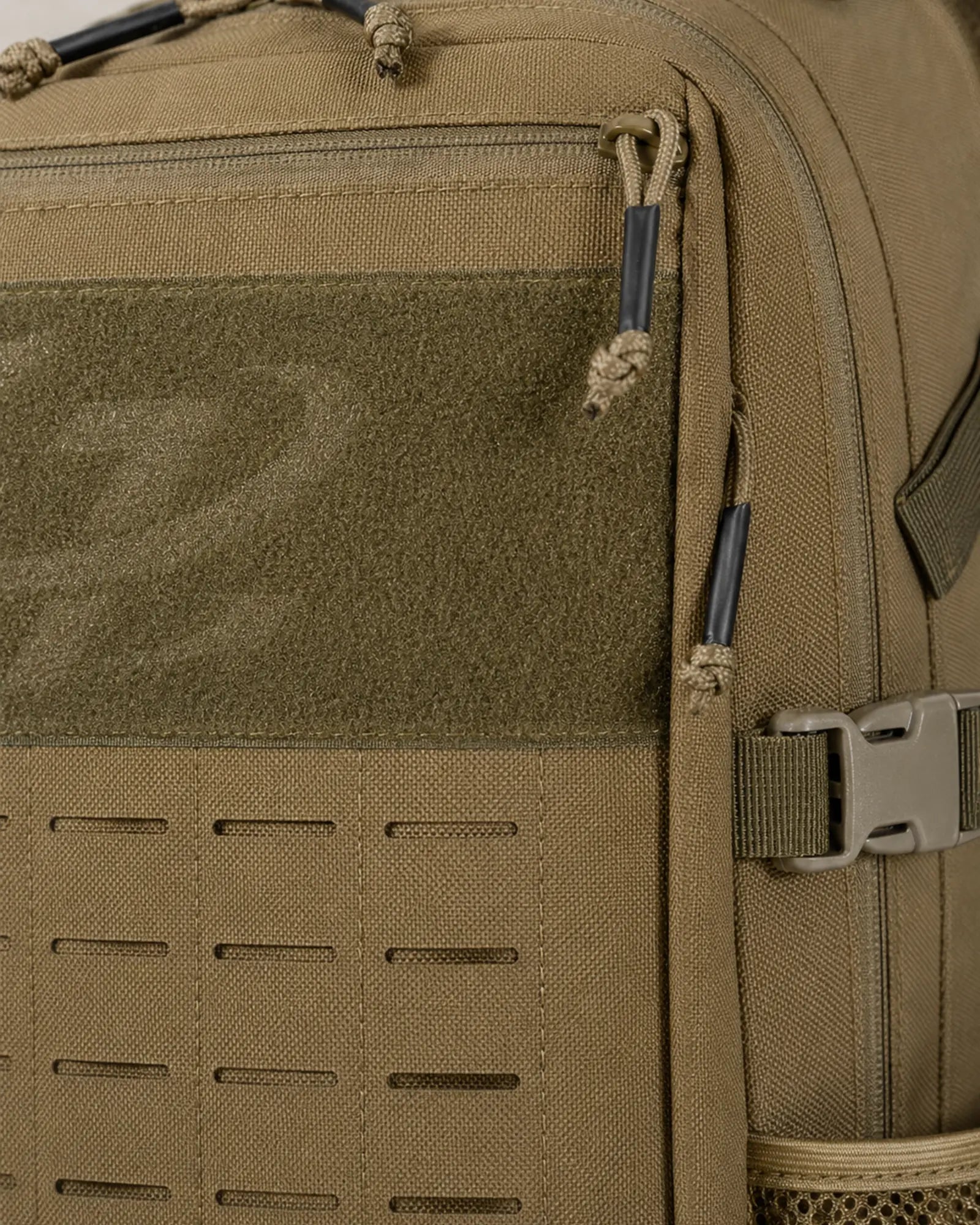 Close-up of Scione backpack laser-cut MOLLE slots zipper and compression buckle